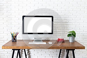 Mockup blank screen computer on wooden desk. desktop empty white screen, with workspace and office supplies on table