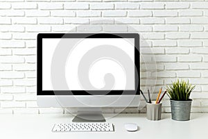 Mockup blank screen computer on a wooden desk. desktop empty white screen, with workspace and office supplies on table