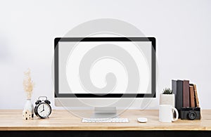 Mockup Blank screen desktop computer and decorations on wood table and white wall background