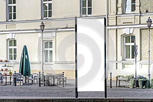Mockup of blank white city outdoor advertising vertical billboard stand in old town street