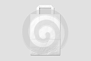 Mockup of a blank white paper shopping bag with handles on light grey background.