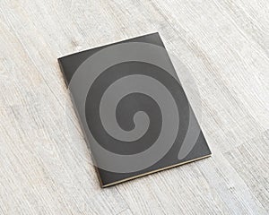 Mockup book with blank black leather cover template paper texture on wood table