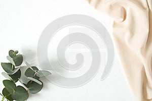 Mockup business card with eucalyptus leaves and nude fabric
