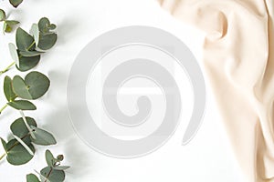 Mockup business card with eucalyptus leaves and nude fabric