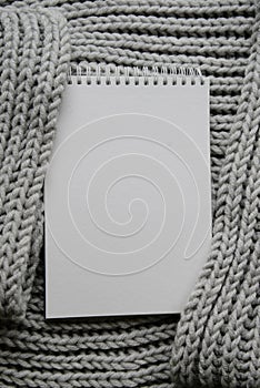 Mockup of cards at white textured watercolor paper background. Top view of spiral notebook Abstract knitting fabric