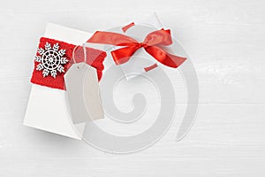 Mockup Christmas Gift Box and tag On Wooden Background With Snowflakes, Greeting card Merry Christmas and Happy New Year