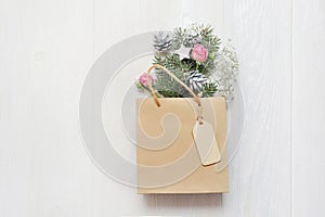 Mockup Christmas gift pack decorated with tree and flower on white wooden background top view. Merry christmas greeting card. Win