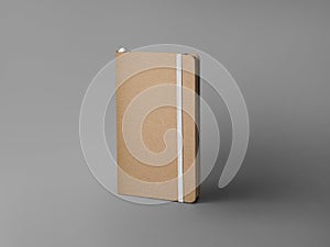 Mockup of closed craft notebook, standing on background with shadows, with white elastic band, bookmark, textured hard cover