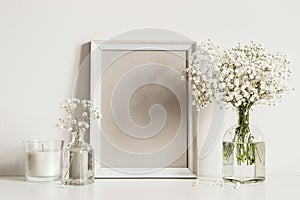 Mockup composition with photo frame, white flowers and candle. Copy space for artwork