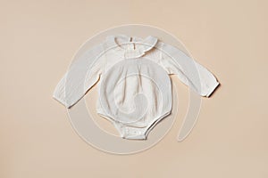 Mockup of cream infant bodysuit made of organic cotton with eco friendly baby accessories on beige backgroundd. Gift for