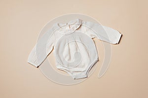 Mockup of cream infant bodysuit made of organic cotton with eco friendly baby accessories on beige backgroundd. Gift for