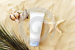 Mockup of a cream in a tube, a moisturizing cosmetic product in a plastic package on a beach background with sand