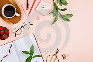 Mockup with cup of coffee on a wooden tray, strawberries in a bowl, opened notebook, glasses, ruscus branches and other accessorie