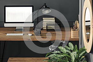 Mockup on desktop computer on wooden desk with lamp in grey work