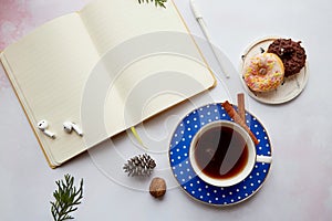 Mockup of empty notepad withwireless earphones, coffee cup with doughnuts. Online work, freelance, taking webinar