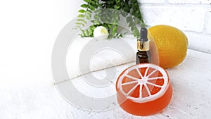 Mockup essential oil bottle with orange citrus soap on white wooden background