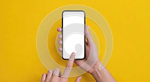 Mockup of female hand holding cell phone with blank screen. Mobile phone with blank white screen on yellow background. Gadget with