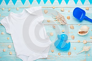 Mockup Flat Lay white baby bodysuit shirt on a blue rustic wood background with a nautical theme, seashells and the sea and