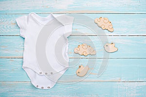 Mockup Flat Lay white baby shirt with wooden toys on a blue background. Layout for the design and placement of logos, advertising