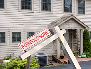 Mockup of foreclosure sign in front of modern townhome due to recession and pandemic