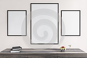 Mockup frames in living room on white wall above wooden desk with books