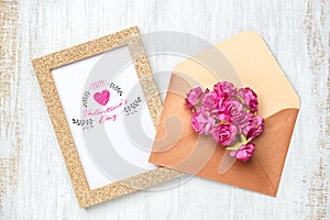 Mockup golden picture frame for Valentines day concept. Flat lay Top view of mock up photo frame with craft rose flowers in