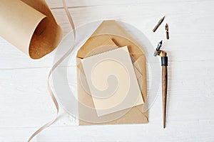 Mockup holiday letter Blank paper and an envelope with pen on wood table, with space for your text, top view