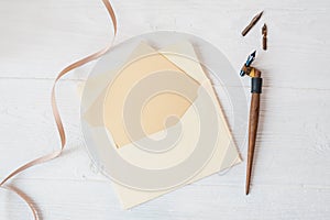 Mockup holiday letter Blank paper and an envelope with pen on wood table, with space for your text, top view