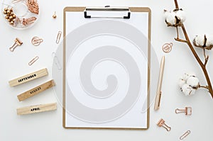 Mockup Home office desk with clip board, paper clamps, golden pen, cotton flowers on a white background. Flat lay