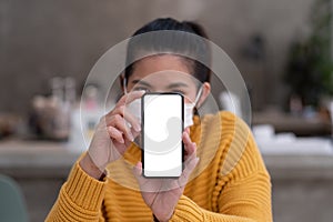 Mockup image of a beautiful woman wear mask while holding mobile phone with blank white screen.