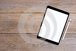 Mockup image of black tablet computer pc with blank white screen with pencil isolated on wood table.