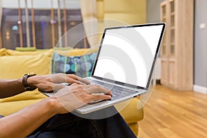 Mockup image of a businessman using laptop with blank white desktop screen working in home