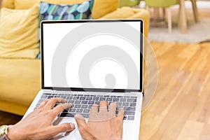 Mockup image of a businessman using laptop with blank white desktop screen working in home