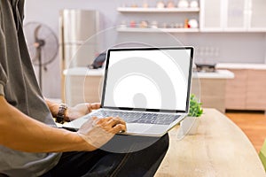 Mockup image of a businessman using laptop with blank white desktop screen working in home