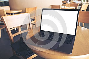 Mockup image of computer laptop with blank white desktop screen on wooden table