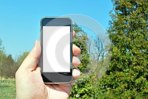 Mockup image of hand holding black mobile phone with blank white screen and green tree forest , nature background