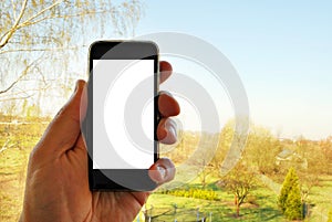 Mockup image of hand holding black mobile phone with blank white screen and green tree forest , nature background