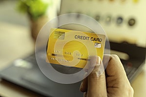 Mockup image of a hand holding credit card while using and typing on laptop.online shopping, online payment