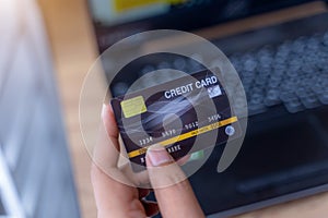 Mockup image of a hand holding credit card while using and typing on laptop.online shopping, online payment