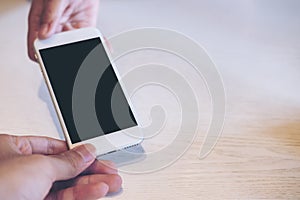 Mockup image of a hand holding , showing and giving white smart phone with blank black screen to another person to receive