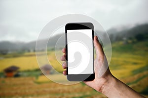 Mockup image of hand holding white mobile phone with blank.