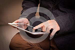 Mockup image of hands holding black tablet pc with blank white desktop screen while sitting in cafe