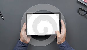 Mockup image of hands holding black tablet pc with blank white desktop screen while sitting in cafe