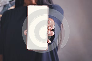 Mockup image of a holding black mobile phone with blank white screen
