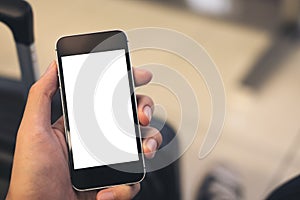 Mockup image of a man`s hand holding and using black mobile phone with blank white screen