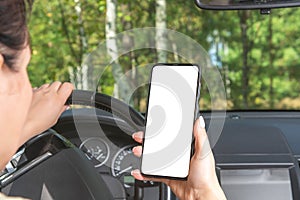 Mockup image. woman driving a car holds a phone in her hand. woman holding blank screen cell phone while driving car