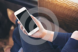 Mockup image of a woman`s hand holding white mobile phone with blank black screen