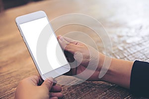 Mockup image of woman`s hands holding and using white mobile phone with blank screen