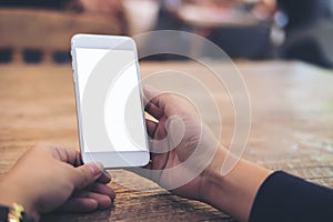 Mockup image of woman`s hands holding and using white mobile phone with blank screen