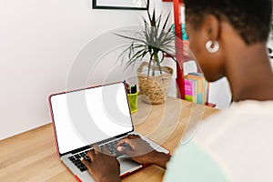 Mockup image of young african woman using laptop computer with blank screen